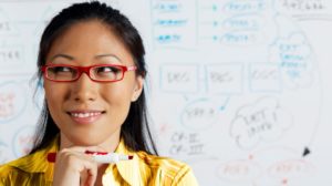 close-up-of-asian-businesswoman-smiling-in-front-of-whiteboard